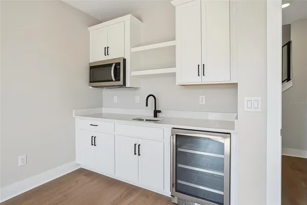 a kitchen with white cabinets and sink