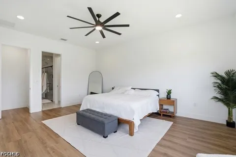 a bedroom with a bed and a potted plant on dresser
