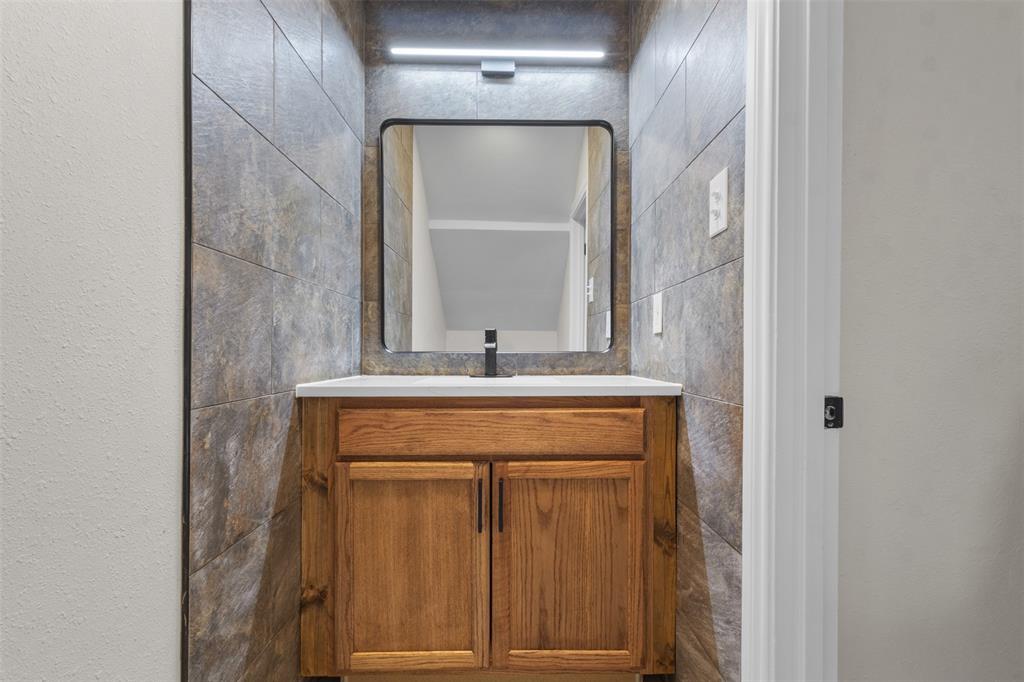 4941 North Hall Street Dallas, TX 75235 - Photo 14 of 18 Half Bathroom featuring vanity and a textured wall