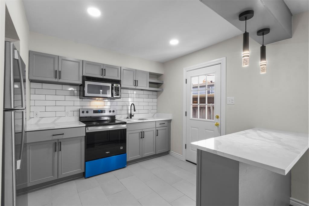 4941 North Hall Street Dallas, TX 75235 - Photo 2 of 18 Kitchen featuring gray cabinetry, stainless steel appliances, open shelves, a peninsula, and recessed lighting
