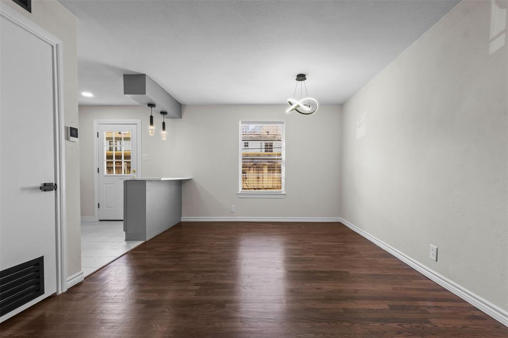 4941 North Hall Street Dallas, TX 75235 - Photo 4 of 18 Unfurnished dining area featuring dark wood finished floors and baseboards