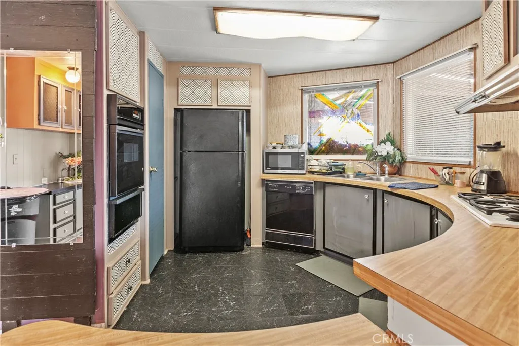 519 West Taylor Street, Unit 252 Santa Maria, CA 93458 - Photo 18 of 52 a kitchen with stainless steel appliances granite countertop a refrigerator a stove and a sink