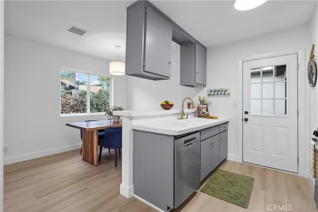 a kitchen with a sink cabinets and wooden floor