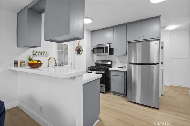 a kitchen with stainless steel appliances a refrigerator a sink and a stove