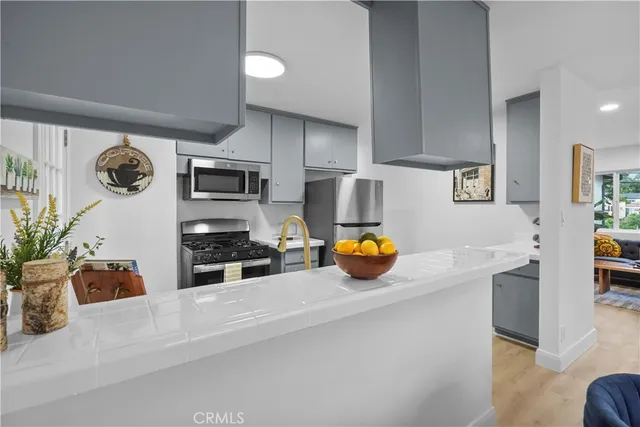 a kitchen with stainless steel appliances a stove a sink a microwave a refrigerator and cabinets