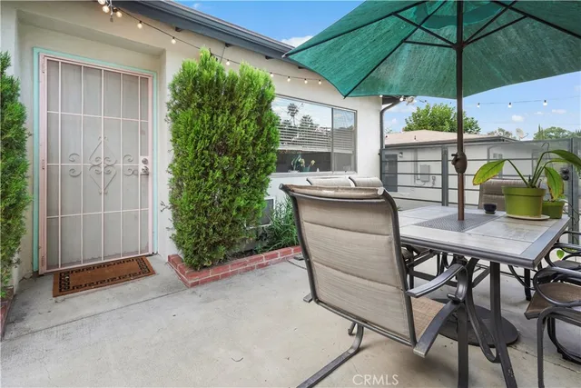 a balcony with furniture and umbrella