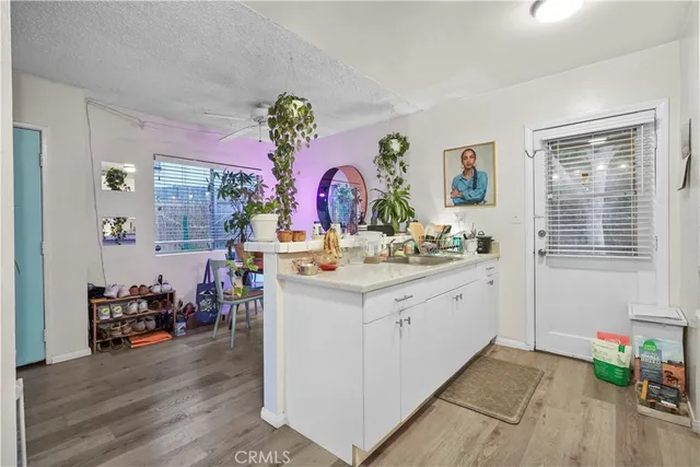a kitchen with granite countertop cabinets stainless steel appliances and a wooden floor