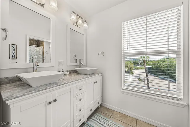 a bathroom with a granite countertop sink a mirror and a window