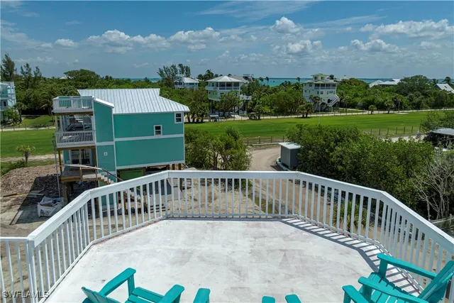 a view of house with wooden deck and outdoor seating