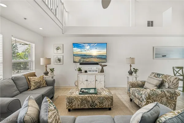 a living room with furniture a large window and a flat screen tv