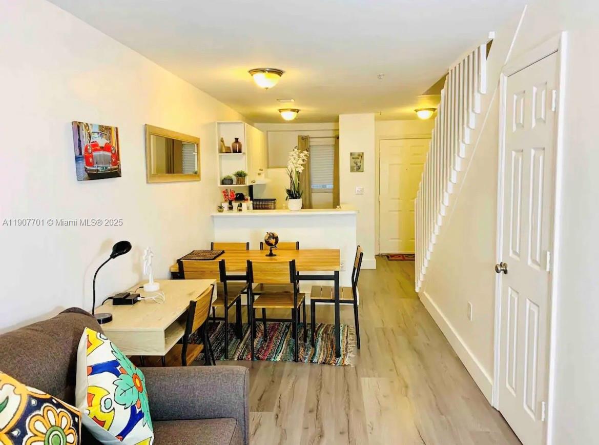 a living room with dining room and wooden floor