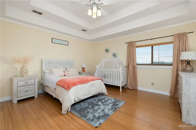 a spacious bedroom with a bed a couch and large windows