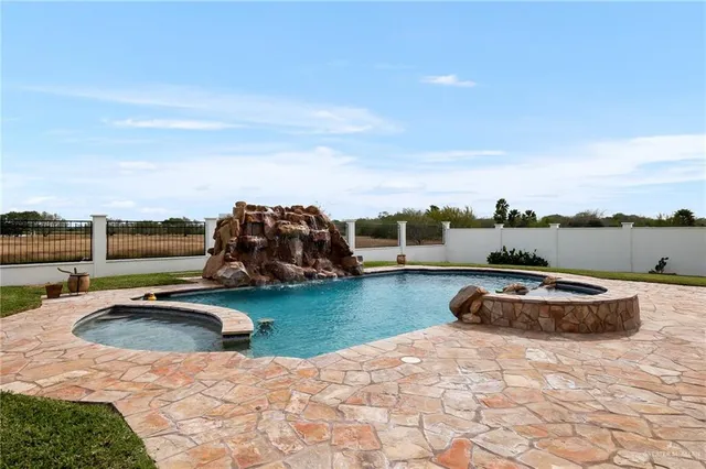 a swimming pool with outdoor seating and yard in back