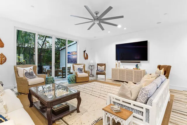 a living room with furniture a flat screen tv and a large window