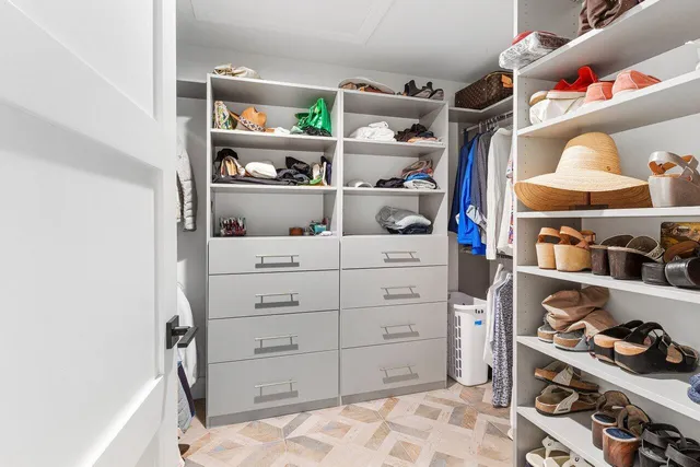 a view of walk in closet with clothes and shoes
