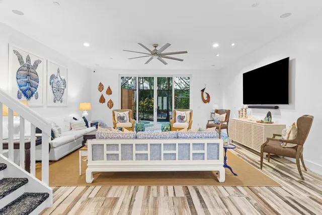 a view of a livingroom with furniture a flat screen tv and floor to ceiling window