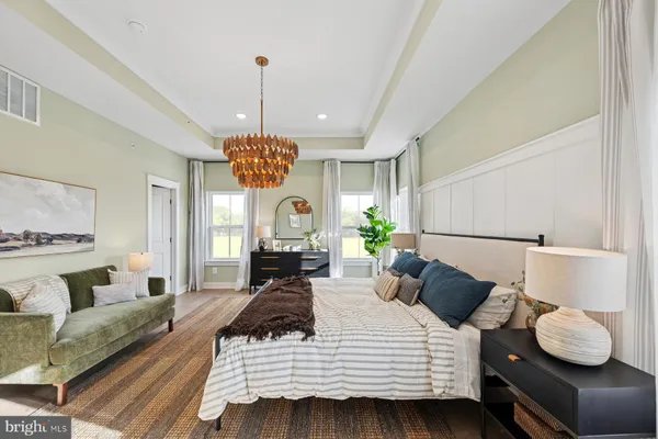 a spacious bedroom with a bed and a chandelier