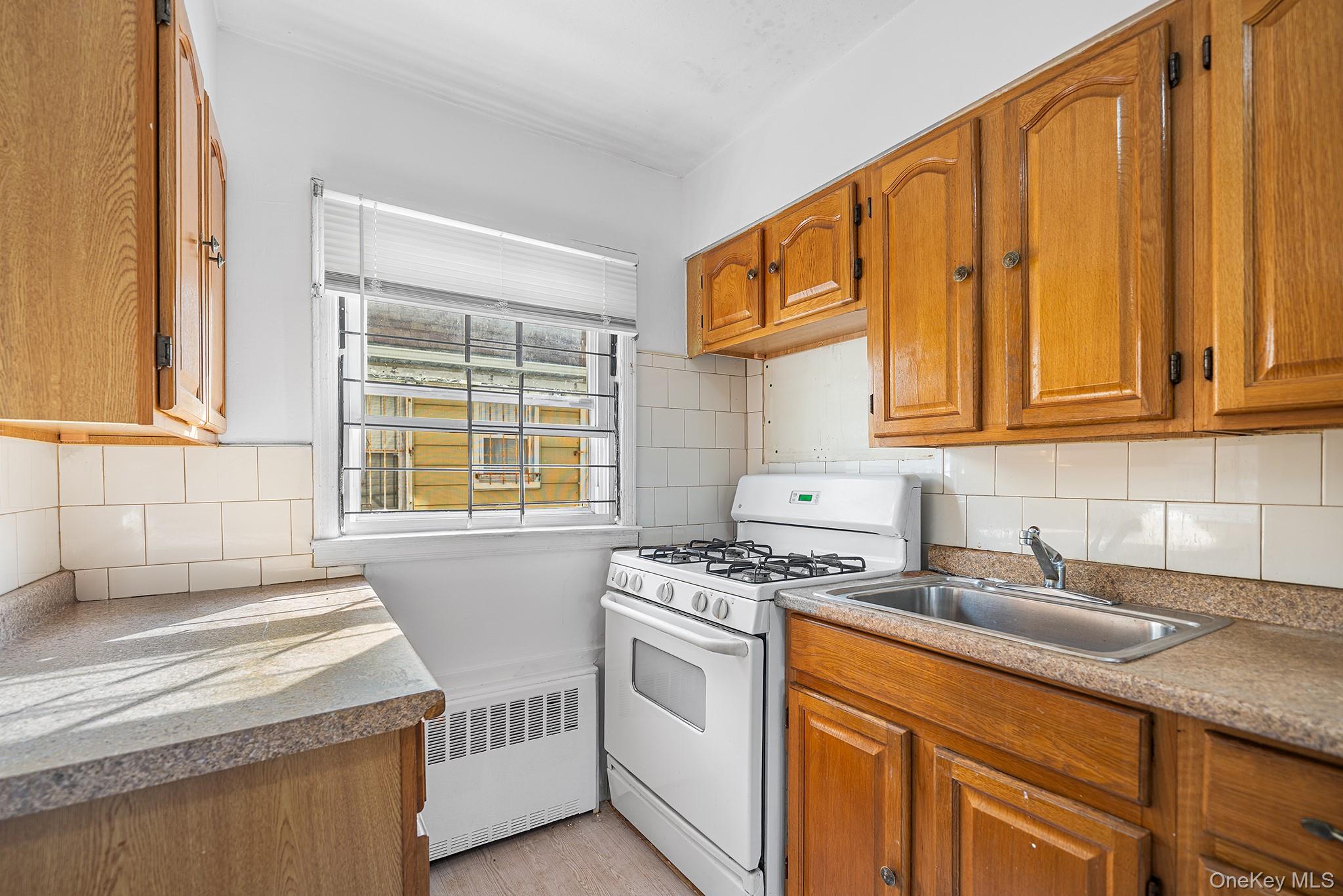 27-11 Deerfield Road Queens, NY 11691 - Photo 13 of 43 a kitchen with stainless steel appliances granite countertop a sink stove and cabinets