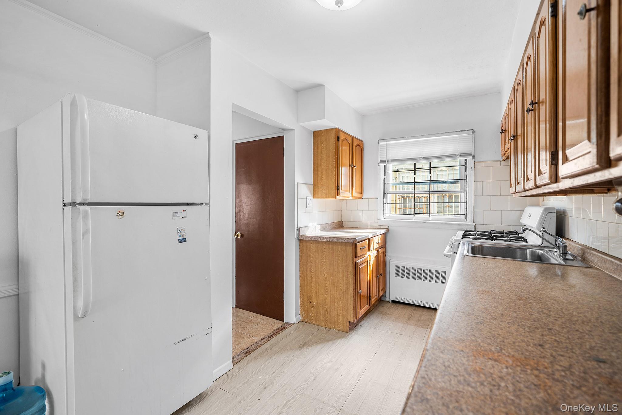 27-11 Deerfield Road Queens, NY 11691 - Photo 14 of 43 a kitchen with refrigerator and window