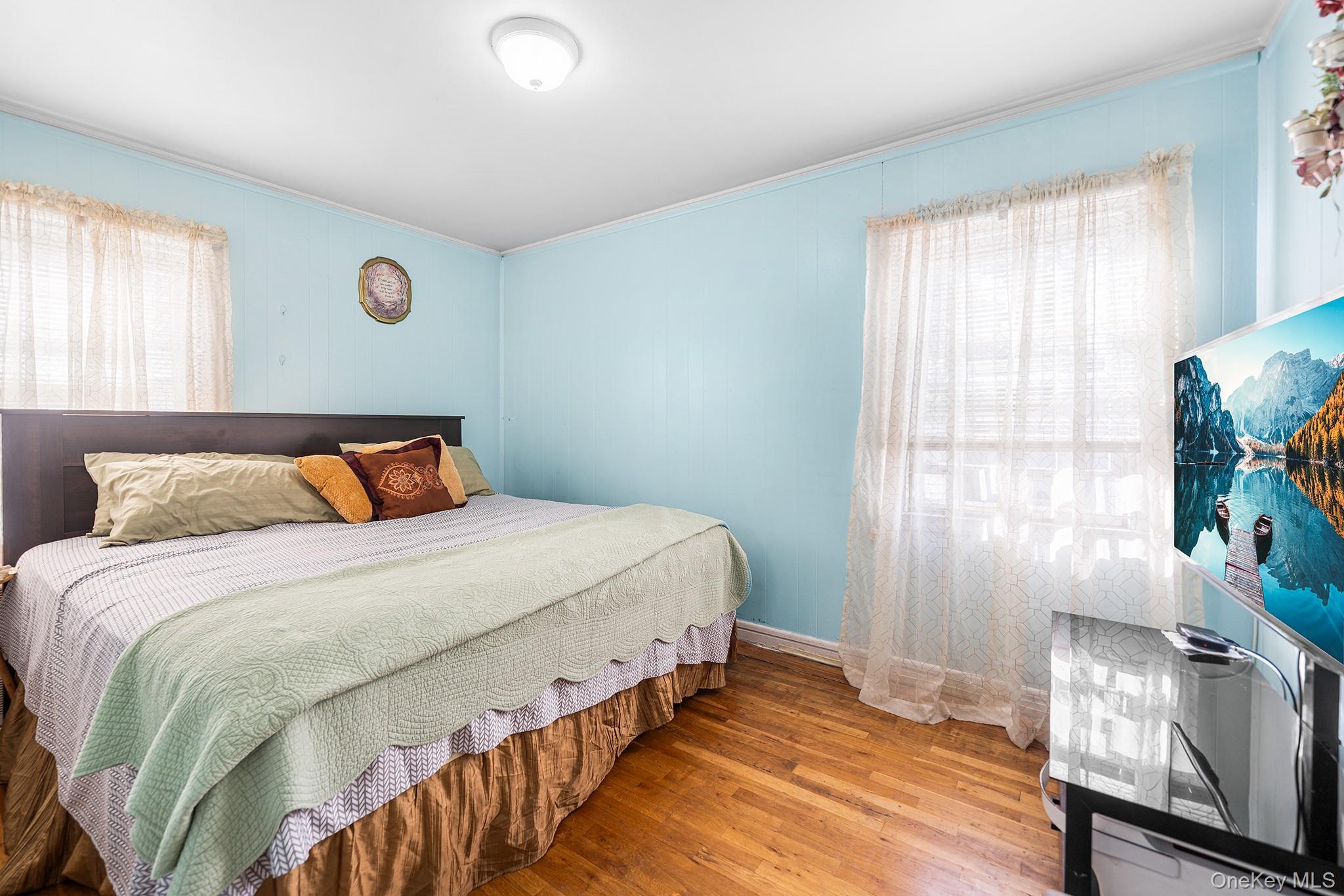 27-11 Deerfield Road Queens, NY 11691 - Photo 16 of 43 a bedroom with a bed and wooden floor