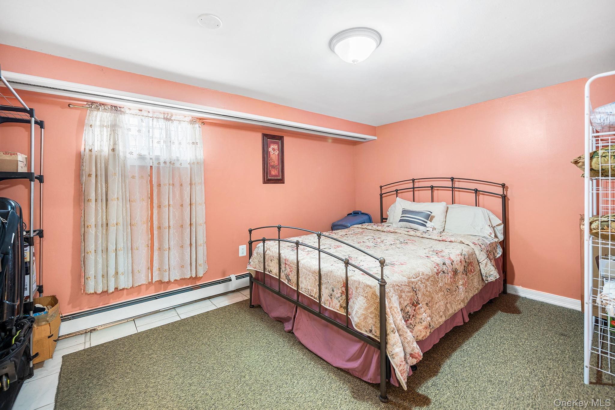 27-11 Deerfield Road Queens, NY 11691 - Photo 22 of 43 a bed sitting in a bedroom next to a window