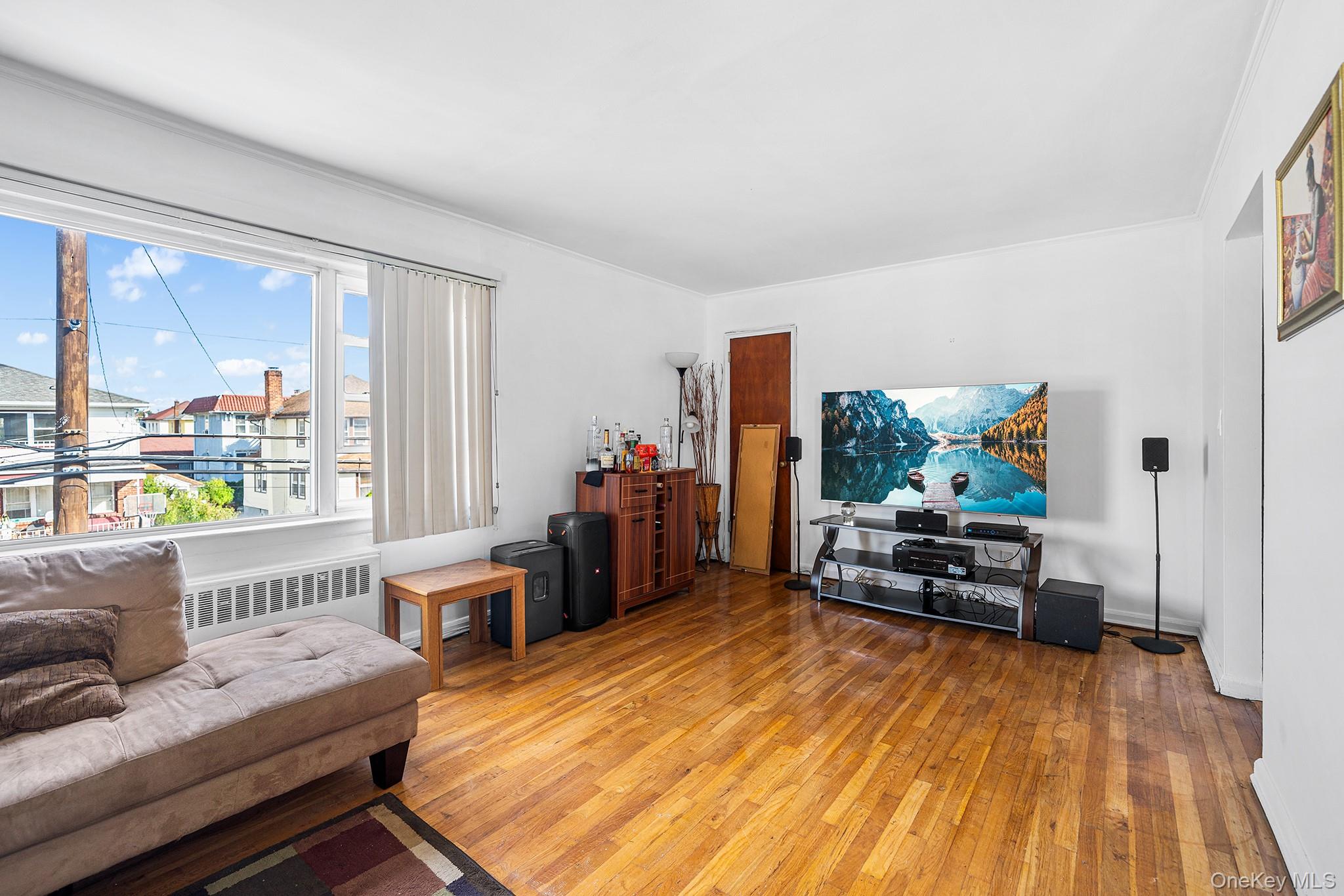 27-11 Deerfield Road Queens, NY 11691 - Photo 29 of 43 a living room with furniture and a wooden floor