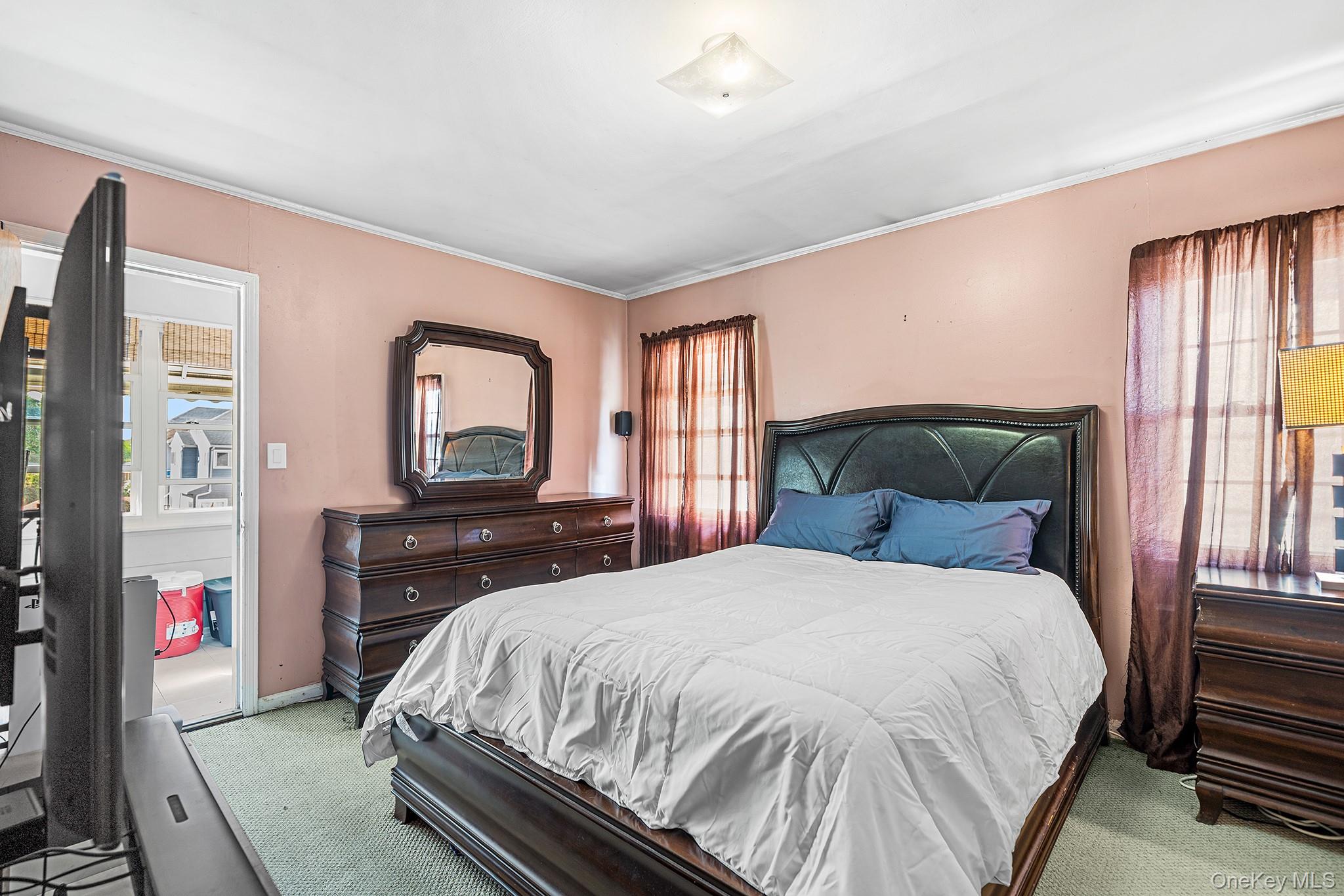 27-11 Deerfield Road Queens, NY 11691 - Photo 34 of 43 a bedroom with a bed and dresser with mirror