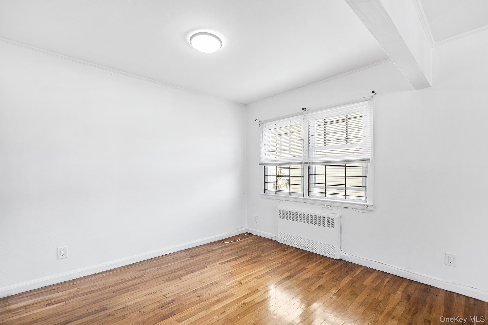 27-11 Deerfield Road Queens, NY 11691 - Photo 9 of 43 an empty room with wooden floor and windows