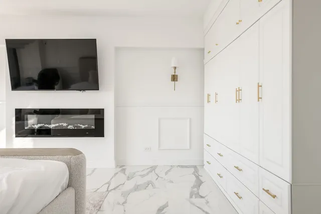 a spacious bedroom with a bed and a flat screen tv