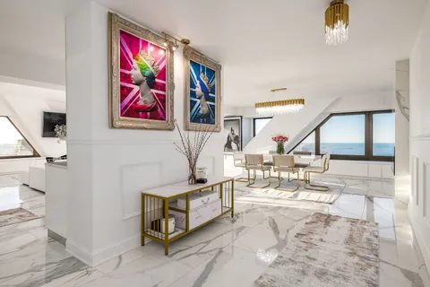 a view of a livingroom with furniture and floor to ceiling window
