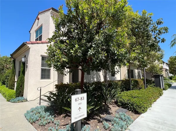 a front view of a house with a tree