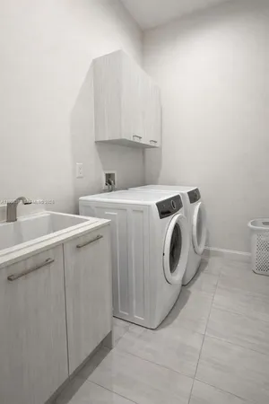 a utility room with sink dryer and washer