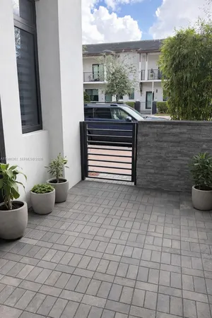 a view of a balcony with chairs potted plants