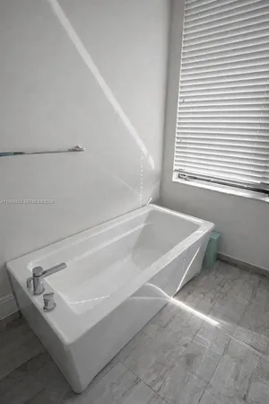 a bathroom with a bathtub and next to a window