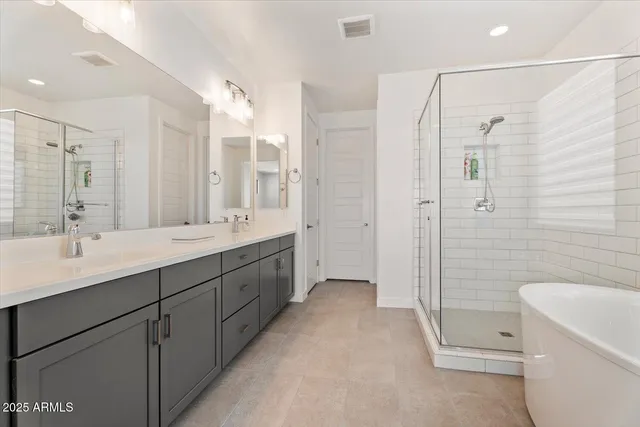 a spacious bathroom with a double vanity sink toilet mirror and shower