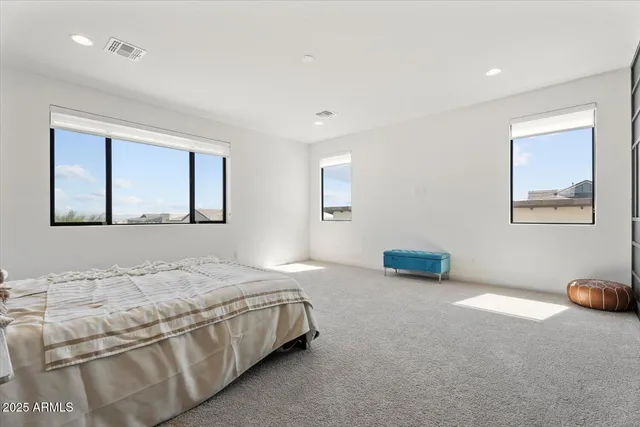 a bedroom with a bed and a painting on the wall