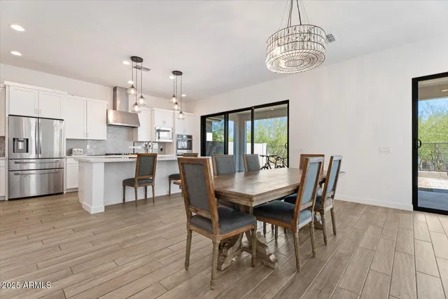 a view of a dining room with furniture a chandelier and wooden floor