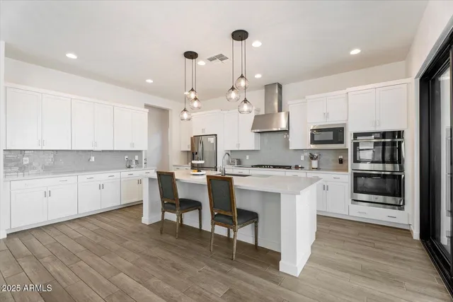 a kitchen with white cabinets stainless steel appliances and kitchen island