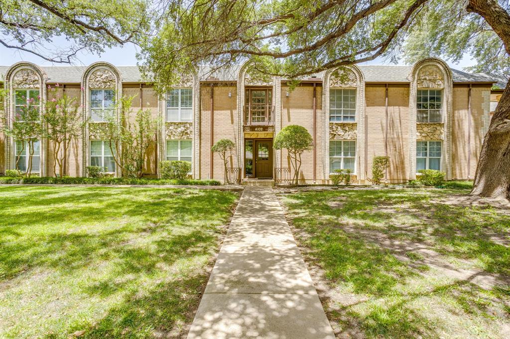 4102 Ridglea Country Club Drive, Unit 1503 Fort Worth, TX 76126 - Photo 17 of 21 Brick facade building with a central entryway, decorative arched window surrounds, and a concrete pathway