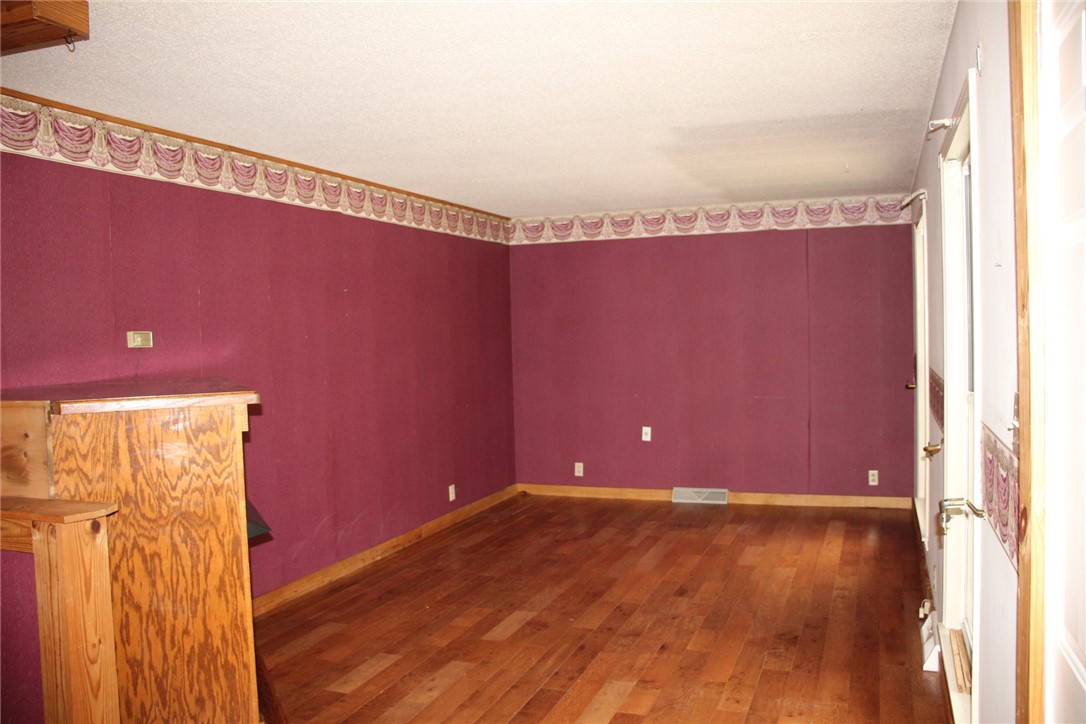 402 Canaan Road Marshall, AR 72650 - Photo 8 of 37 Room featuring wood-finish flooring, a built-in wooden structure, and a wall border