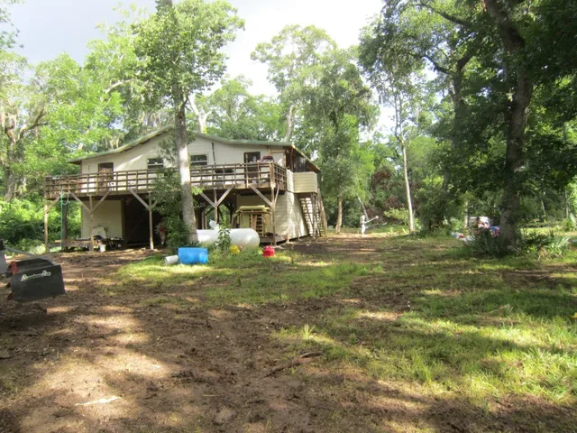 a view of a house with yard and a trees