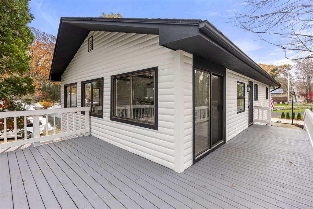 a view of a house with a deck and furniture