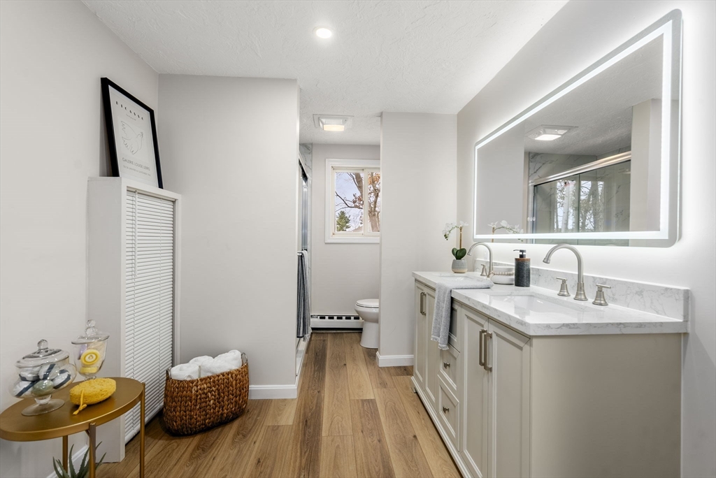6 Henry Road Webster, MA 01570 - Photo 16 of 39 a spacious bathroom with a granite countertop sink a mirror a vanity and toilet