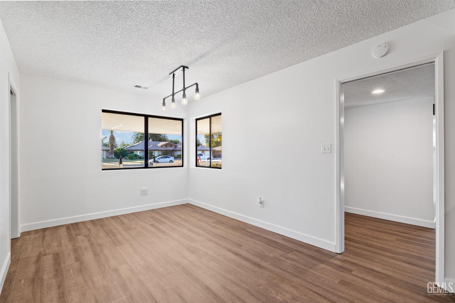 Undisclosed Address Bakersfield, CA 93314 - Photo 22 of 60 a view of an empty room with wooden floor and a window
