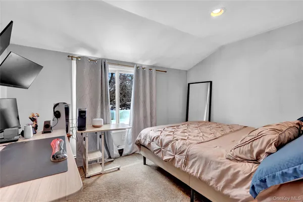 a bedroom with a bed flat screen tv and window