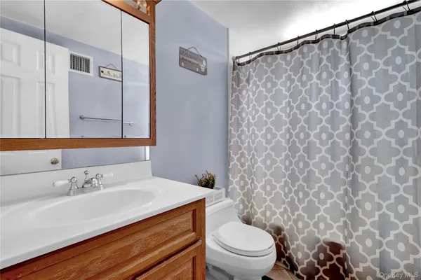 a bathroom with a sink mirror vanity and toilet