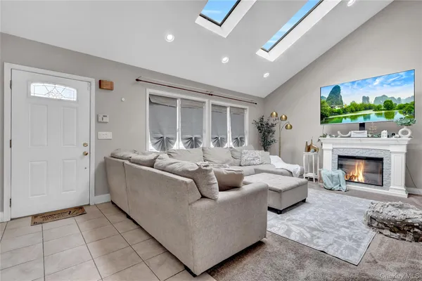 a living room with furniture a fireplace and a flat screen tv