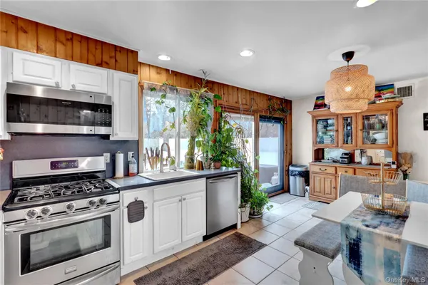 a kitchen with stainless steel appliances a stove a sink and a microwave