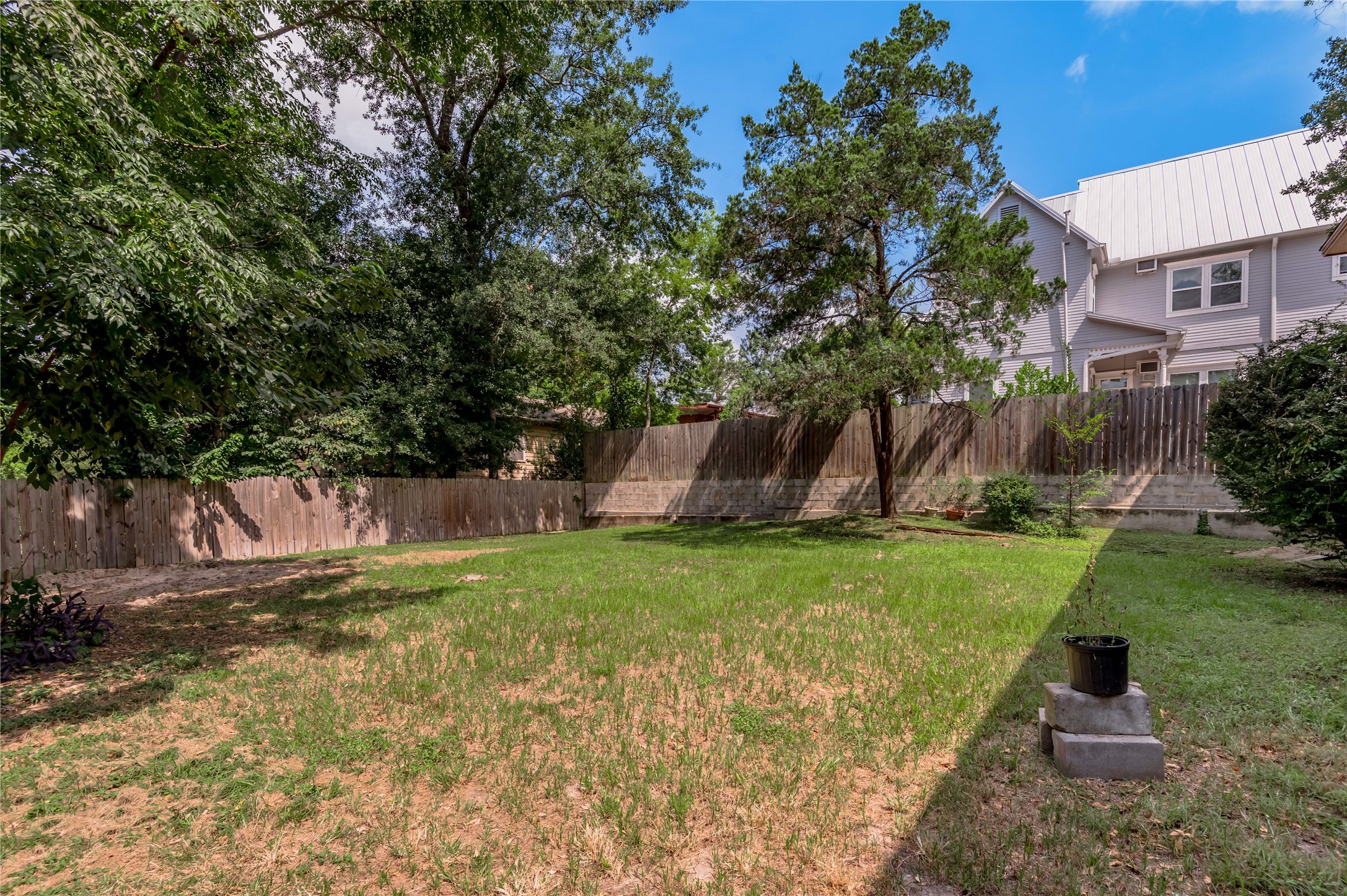 818 University Avenue, Unit 8 Huntsville, TX 77320 - Photo 21 of 22 a backyard of a house with plants and large trees