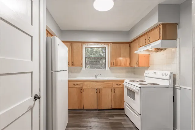 a kitchen with a sink a refrigerator and window